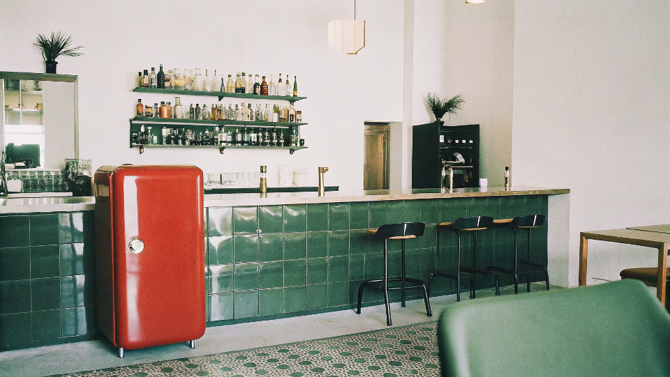 A stylish bar interior featuring a prominent retro fridge