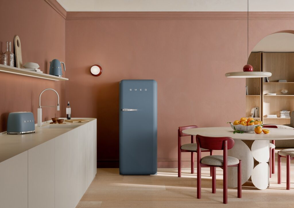 A red 1950s-style retro refrigerator standing alone