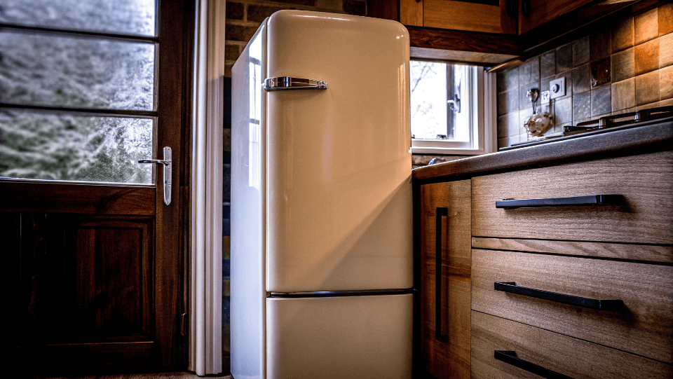A stylish, cream-colored retro refrigerator in a modern kitchen