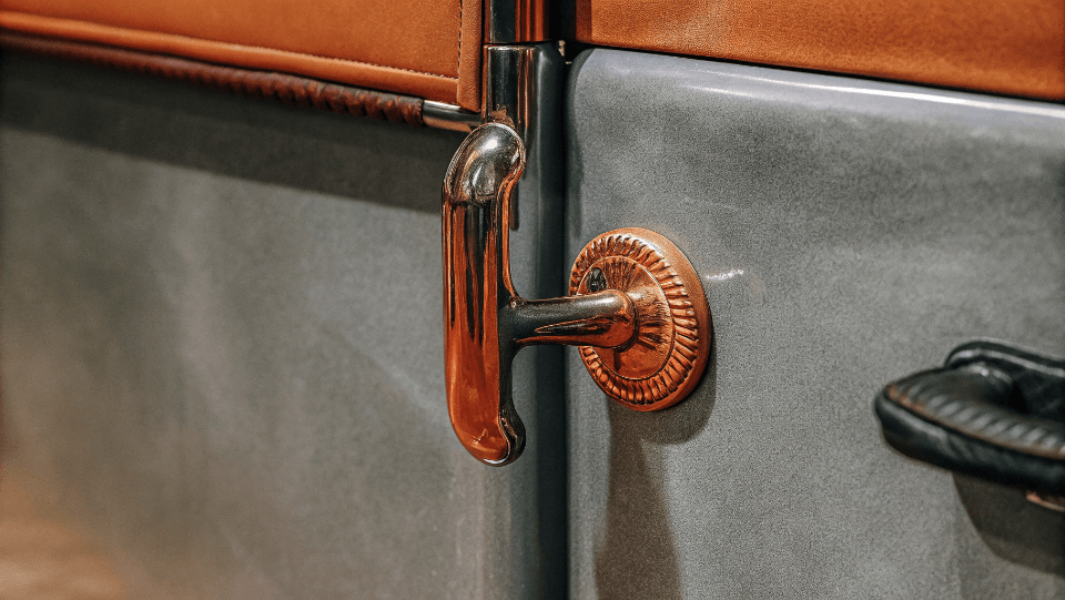 Close-up of the metal handle and emblem on a vintage refrigerator