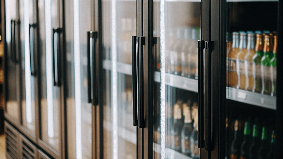 a row of glass door beverage fridges in a commercial setting