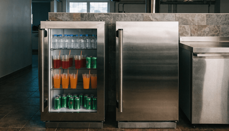 A side-by-side comparison of a glass door fridge and a solid door fridge in a commercial kitchen.